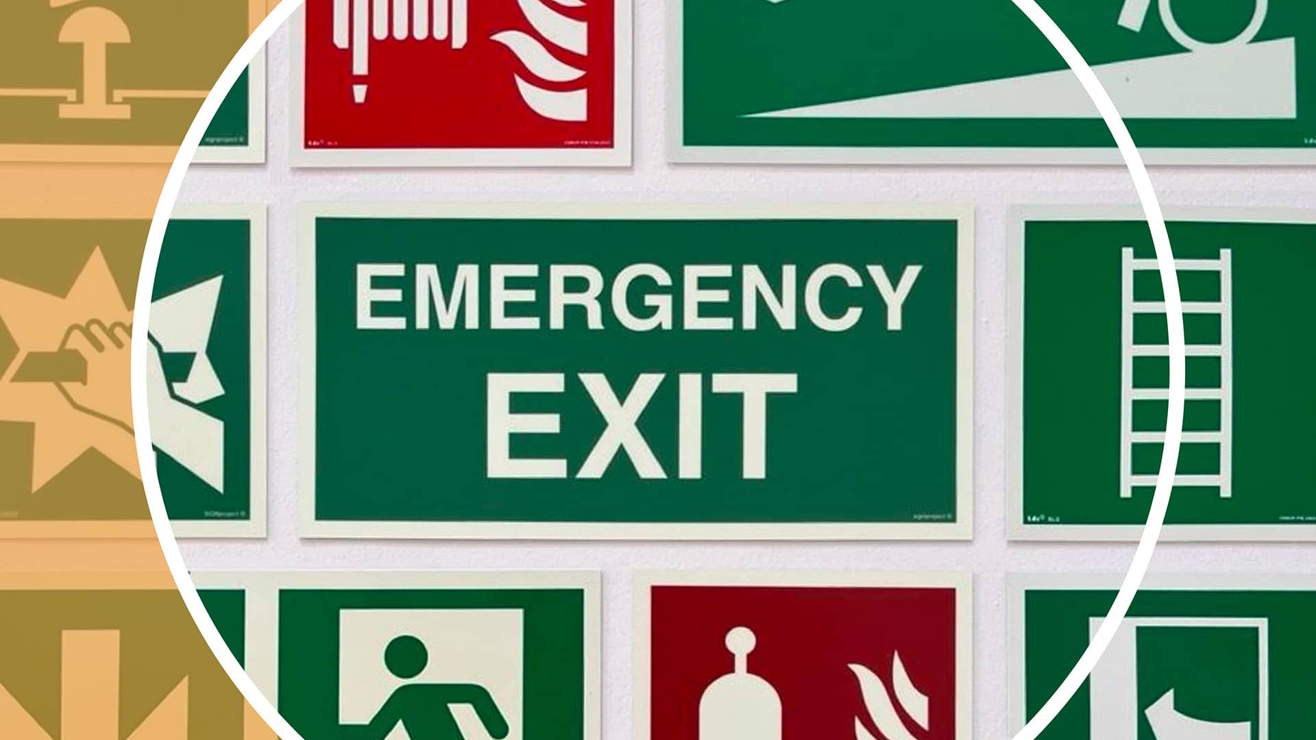 Sammlung von Sicherheitsschildern, darunter ein großes grünes Schild mit der Aufschrift „Emergency Exit“, umgeben von Piktogrammen für Fluchtwege, Feuerlöscher und Notausgänge.