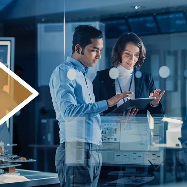 Zwei Fachpersonen analysieren gemeinsam Daten auf einem Tablet in einem modernen Büro mit vernetzten Arbeitsplätzen und grossen Bildschirmen. Die Szene steht für digitale Transformation, datenbasierte Entscheidungen und effizientes Customer Relationship Management im technologischen Unternehmensumfeld.