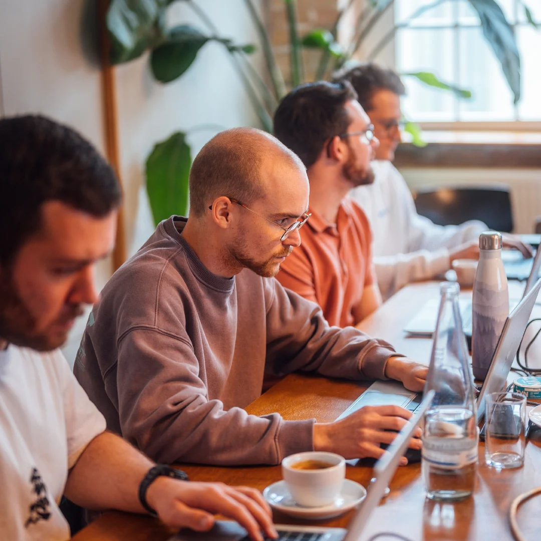 Drei BSI-ler arbeiten konzentriert am BSI Campus mit Laptops an praxisnahen Aufgaben. Die Szene zeigt kollaboratives Arbeiten und Weiterbildung im Bereich Customer Relationship Management mit der BSI Customer Suite und unterstreicht den Austausch von Wissen sowie moderne Arbeitsmethoden.