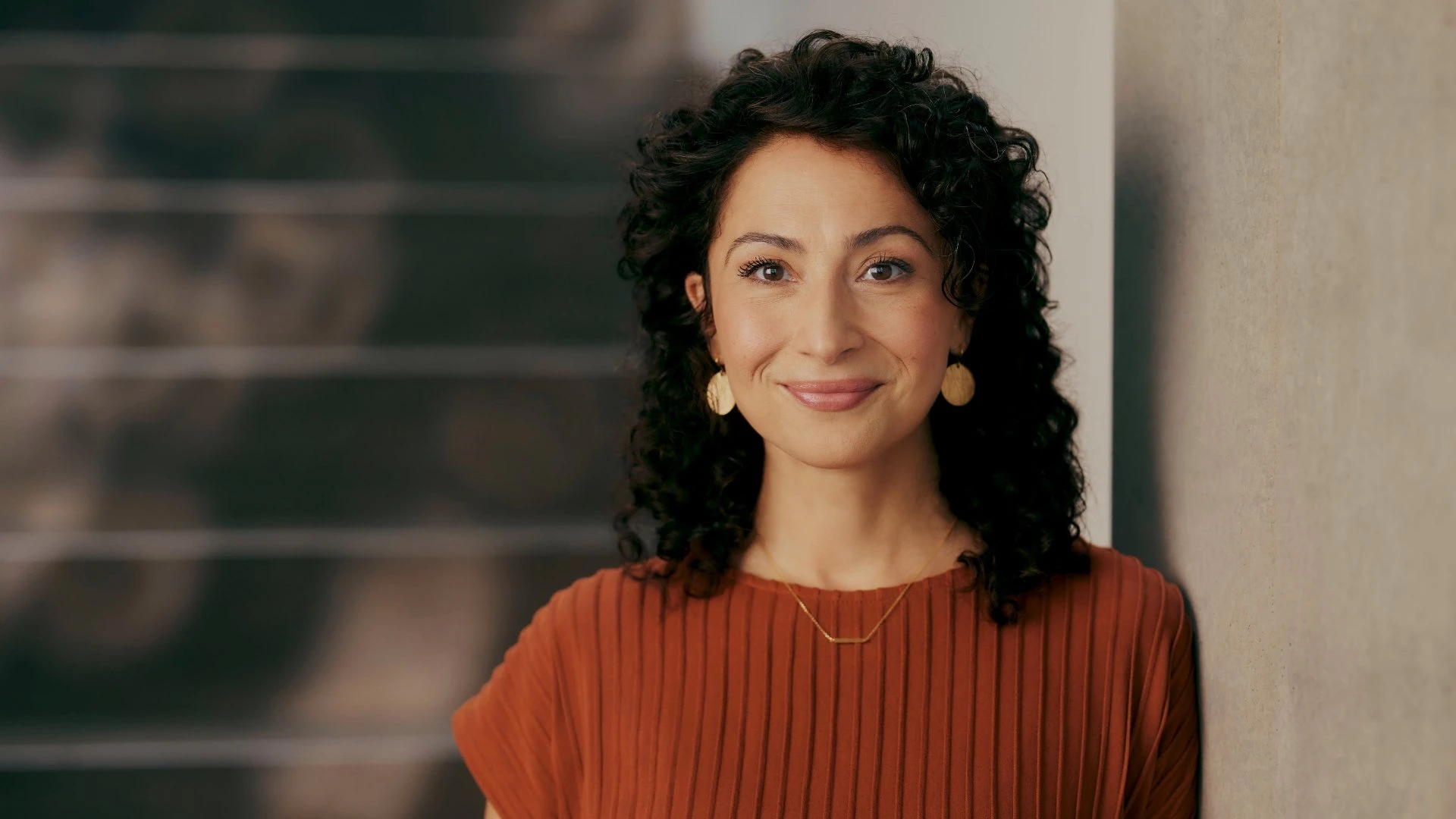 Ritratto di una donna sorridente in un moderno contesto aziendale. Rappresenta una figura decisionale nel settore assicurativo che promuove la digitalizzazione nelle assicurazioni con un moderno CRM per le assicurazioni.