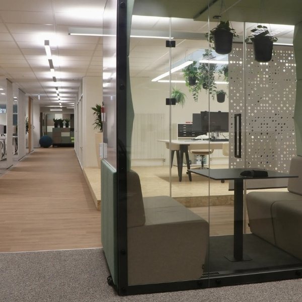 Modernes Büro von BSI Software in Bern mit verglastem Meetingraum, Arbeitsplätzen und Pflanzen in heller, offener Arbeitsumgebung. Der Standort Bern bietet Mitarbeitenden eine moderne Office-Infrastruktur für Zusammenarbeit und Entwicklung.