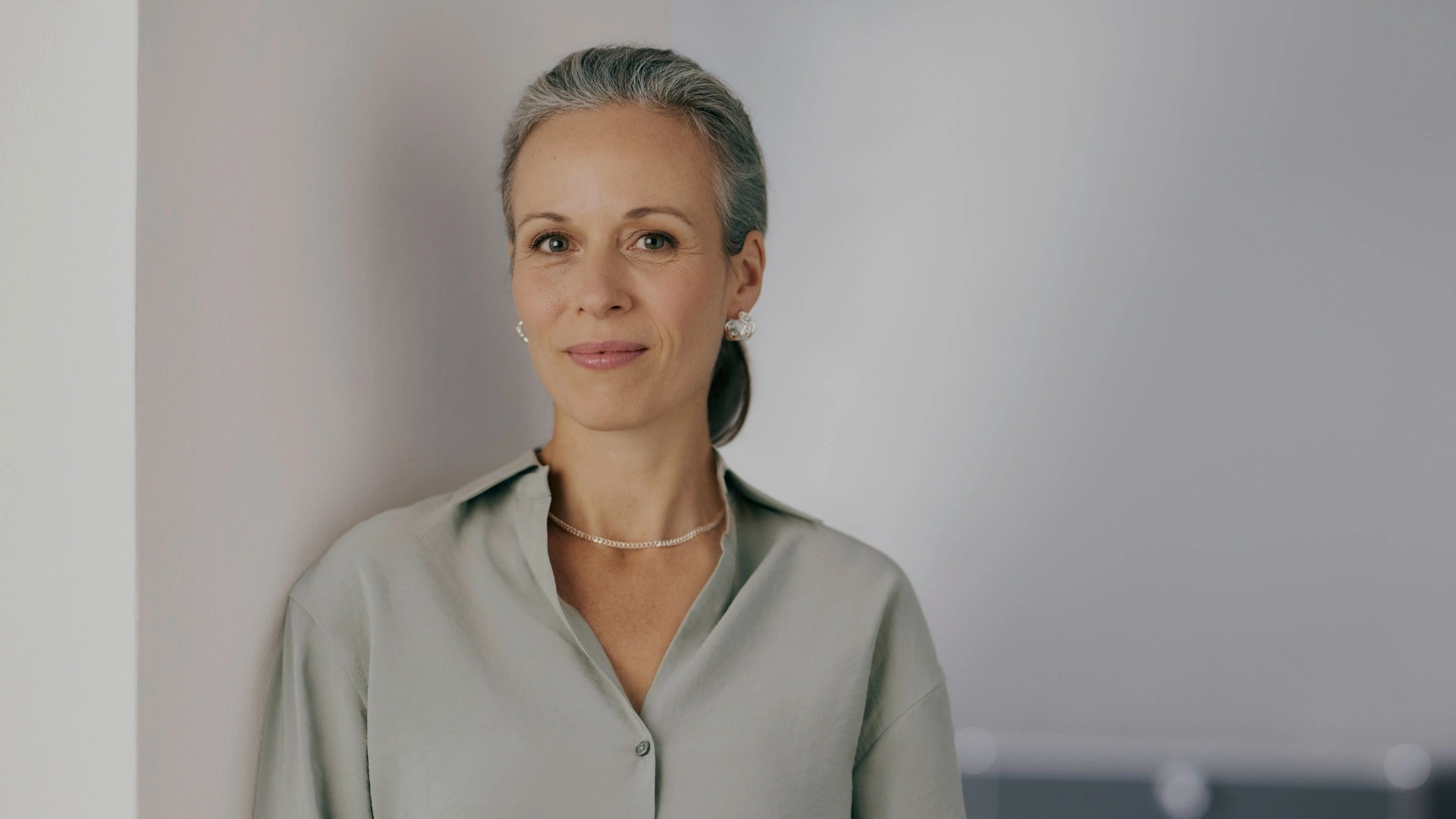 Porträt einer erfahrenen Frau im modernen Business-Umfeld. Sie steht sinnbildlich für eine Entscheiderin im Finanzsektor, die die Digitalisierung im Banking mit einem CRM für Banken und Finanzdienstleister, welches Kernbankensysteme nahtlos integriert, vorantreibt.
