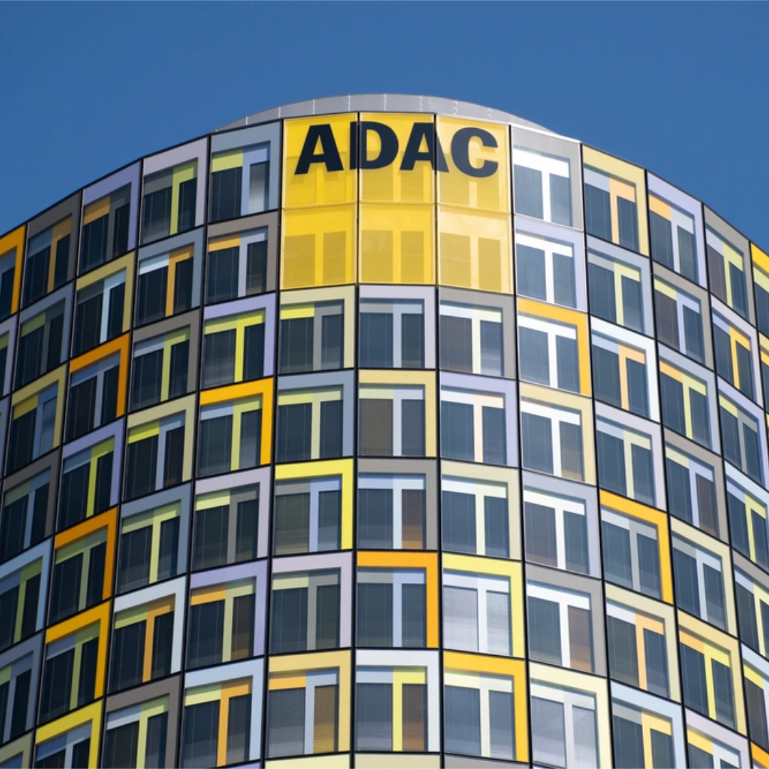 ADAC Hauptsitz mit moderner Glasfassade in Gelb und Grau als Symbol für die grösste Datenmigration Deutschlands auf die BSI Customer Suite. Das Bild steht für digitale Transformation, Customer Relationship Management und zukunftsorientierte IT-Infrastruktur.