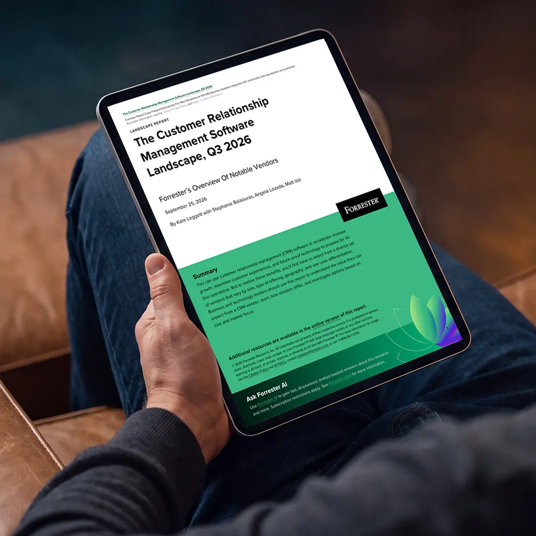 Ein Mann sitzt auf einem braunen Ledersofa und liest auf einem Tablet den Forrester-Report «The Customer Relationship Management Software Landscape, Q3 2026». Der Report bietet einen Überblick über relevante CRM-Softwareanbieter und beleuchtet die aktuelle Marktlandschaft im Bereich Customer Relationship Management.