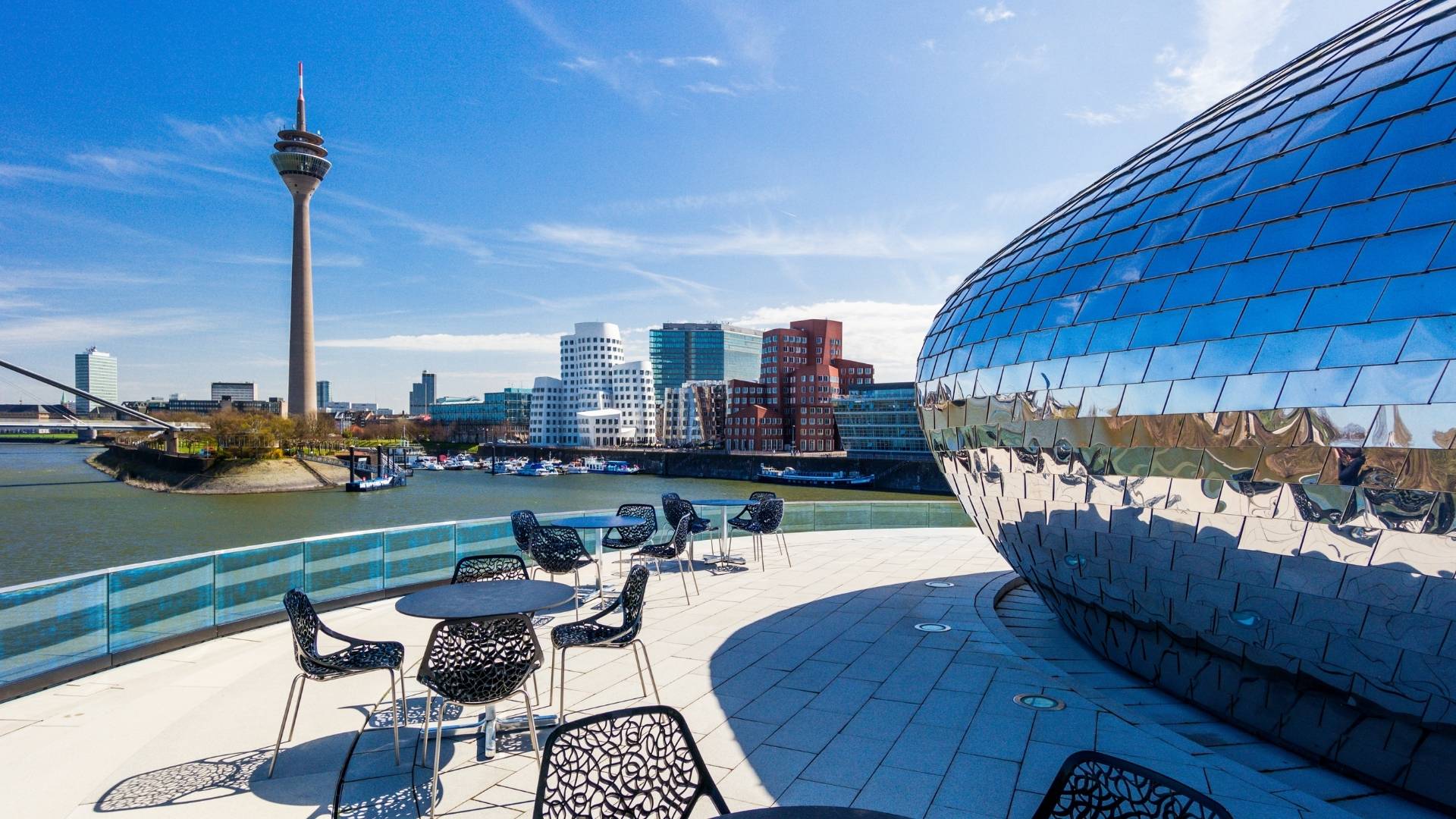 Blick auf den Düsseldorfer Medienhafen mit Rheinturm, moderner Architektur und spiegelnder Glasfassade am Rhein. Im Düsseldorfer Medienhafen befindet sich ein top modernes Büro von BSI Software.